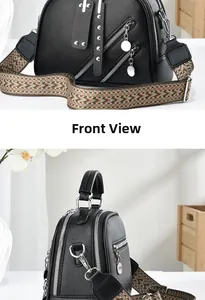 Détail du sac à main en cuir noir grainé avec zips argentés et bandoulière ethnique