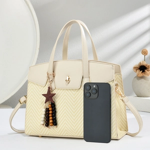 Detail of straw woven tote bag with heart lock and star pendant accessory