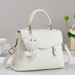 Elegant white lychee leather handbag with golden hardware and cute plush monster charm