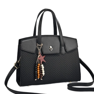 Large black woven shoulder bag with golden heart buckle and colorful star charm detail