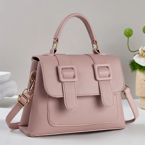 Detail shot of dusty pink handbag texture with high-quality pebbled leather and gold buckle