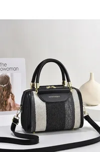 Detail of contrast stripe tote bag showing gold hardware and leather flap texture