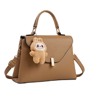 Borsa a mano marrone in pelle martellata con chiusura dorata e ciondolo di peluche