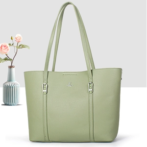 Sage green lychee leather tote bag with silver buckles and elegant floral background