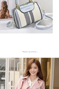 Detailed view of color-block striped Boston bag with blue leather handles and metal zip
