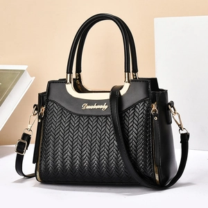 Detailed close-up of V-shaped woven texture on high-quality black leather handbag