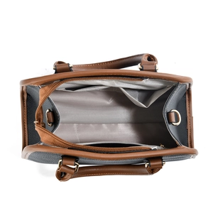 Detail view of the multi-compartment interior with zipper pocket in a two-tone handbag