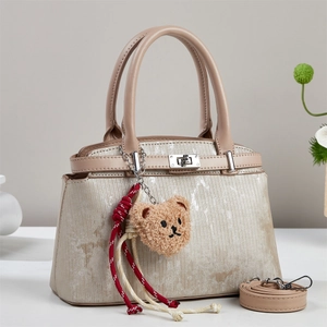 Large champagne striped tote bag with leather trim and bear pendant for women