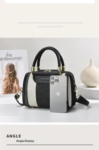 Detail of striped canvas tote bag with leather handles beside a phone for size reference