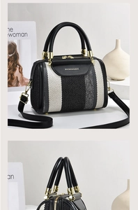 Detailed view of striped crossbody bag with gold hardware and leather top handles