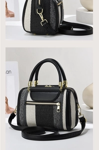 Detail of contrast stripe canvas tote with gold hardware and dual leather handles