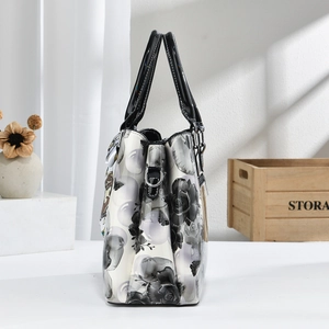 Détail du sac à main floral avec motifs roses noires et anneaux en métal argenté