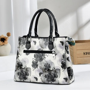Vue détaillée du sac à main fleuri avec poignées noires, fermeture éclair et foulard de soie