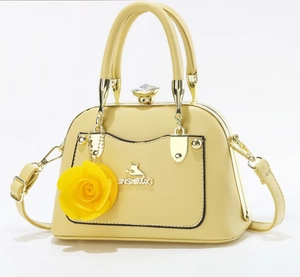 Detail of yellow faux leather handbag with golden cat logo and large floral ornament