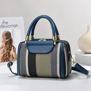 Blue Boston pillow handbag with woven stripes, leather handles and adjustable shoulder strap