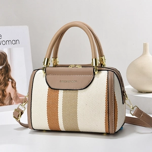 Minimalist woven pillow handbag with orange and brown stripes and a leather handle