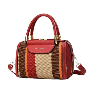 Minimalist red Boston bag with colorful striped weave panels and gold hardware detail