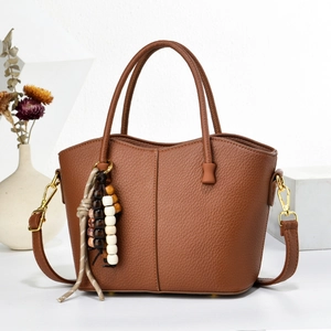 Brown lychee leather handbag with beaded tassel charm and adjustable shoulder strap