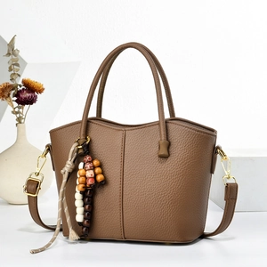 Retro brown lychee pattern bucket bag with ethnic beaded charm and gold hardware