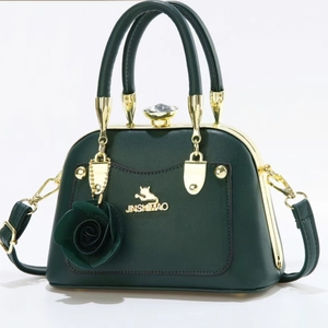Dark green leather handbag with golden cat logo and decorative rose pendant