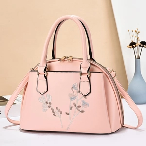 Nahaufnahme der eleganten rosa Handtasche mit Silberstickerei und Goldbeschlägen