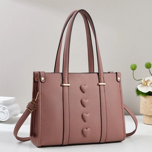 Dusty rose leather tote bag with heart decorations and adjustable shoulder strap