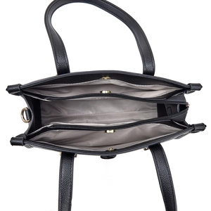 Detailed interior of black leather tote bag with triple compartments and grey herringbone lining
