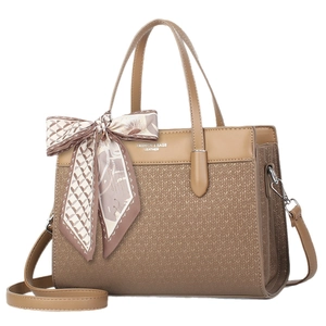 Brown leather crossbody bag with woven texture and decorative floral handle scarf