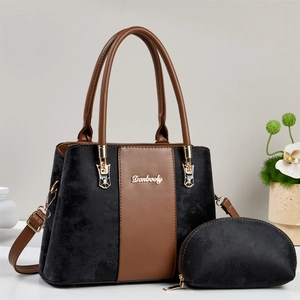 Detail of two-piece handbag set featuring black suede and brown leather contrast design