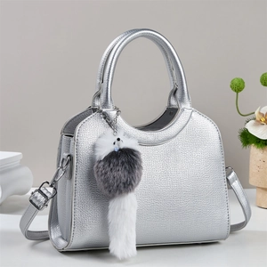 Détail du sac seau argenté avec bandoulière chaîne et breloque en peluche douce