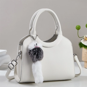 Détail du sac seau blanc en cuir litchi avec quincaillerie argentée et pompon en peluche