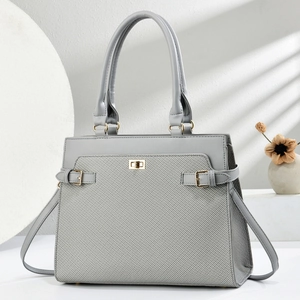 Deep grey tote bag with metal twist lock and dual handles on a minimalist background