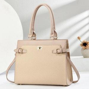 Detailed macro view of beige woven tote bag with gold twist lock and smooth leather trim