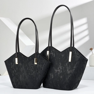 Classic black oil leather tote bag with V-shaped opening and gold metal clasp hardware