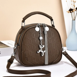 Brown half-round crossbody bag with chain-link texture and metal tassel pendant
