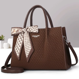 Détail d'un sac cabas café avec texture tissée, poignées en cuir et nœud en foulard