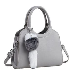 Sac à main gris en cuir grainé avec poignées argentées et porte-clé décoratif en fourrure