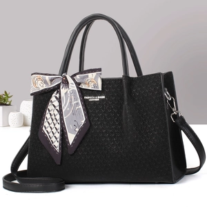 Détail du cabas tissé noir avec foulard en soie et bandoulière en cuir réglable