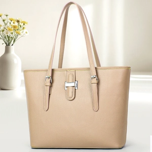 Detail of lychee pattern leather tote bag with silver buckle on a minimalist desk