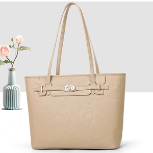 Detail of beige lychee textured tote bag with elegant twist lock and slender straps