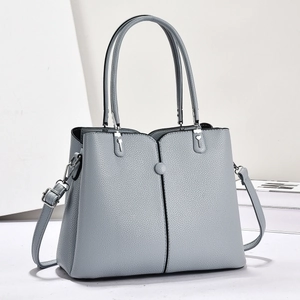 Detail der grau-blauen Handtasche mit Litschi-Struktur und silbernen Beschlägen