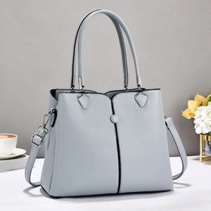 Detailed texture of light blue-grey lychee pattern leather handbag with shoulder strap