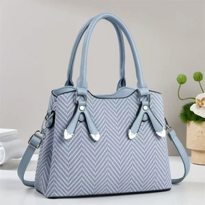 Sac à main bleu gris avec texture à chevrons, rivets argentés et poignées supérieures