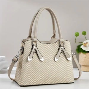 Gros plan sur un sac à main beige tissé à chevrons avec finitions en similicuir