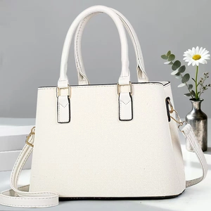 Close-up of beige crossbody bag with premium leather texture and gold hardware details