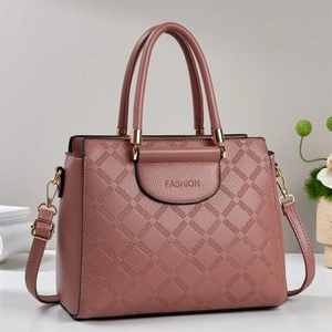 Pink faux leather tote bag with geometric embossing and adjustable shoulder strap