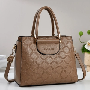 Detail of tan pebble leather tote featuring G-pattern embossing and gold hardware