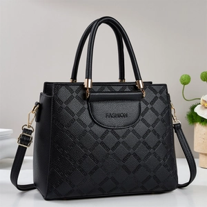 Detail of black pebbled PU leather tote with geometric diamond quilting and gold hardware