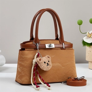Brown faux leather crossbody bag with metal twist lock and cute teddy bear charm