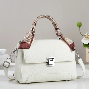 Detail of white lychee leather handbag with silver square lock and patterned silk scarf handle